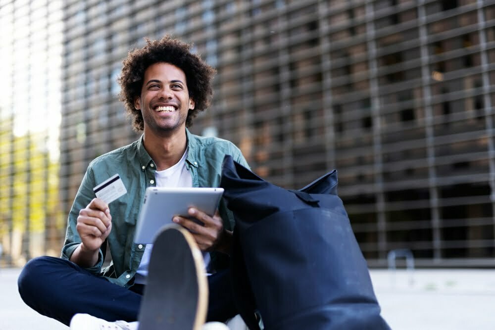 Black Man Smiling, Holding Credit Card and Tablet
